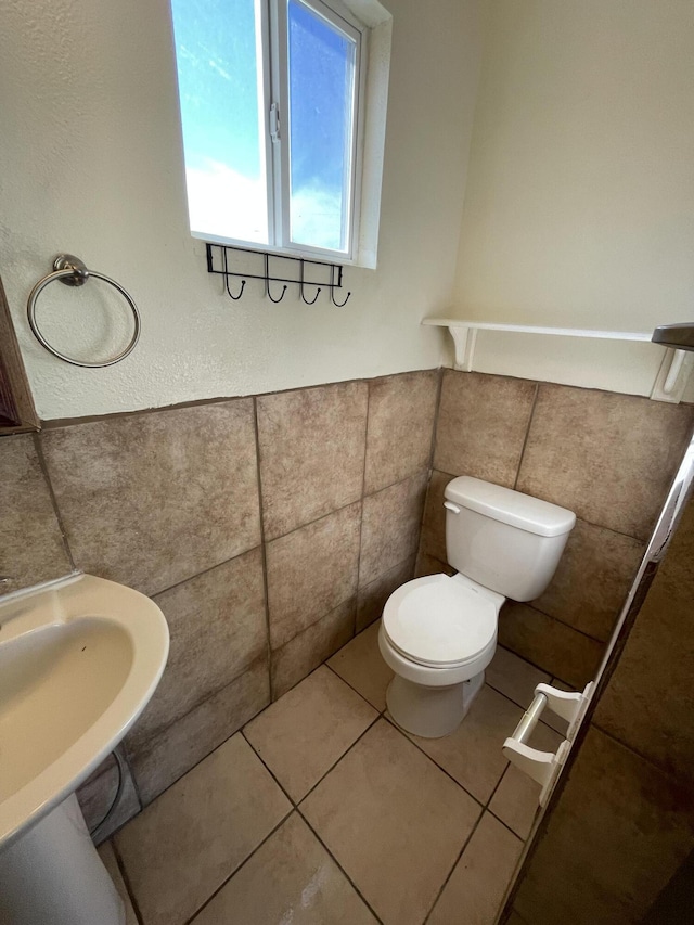 2010 W Lumber St, Lancaster, CA 93536 - half bathroom featuring tile walls, toilet, a sink, tile patterned floors, and wainscoting