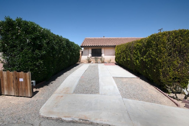 21561 Sheridan Ct, California City, CA 93505 - view of front facade with stucco siding, a tile roof, and fence