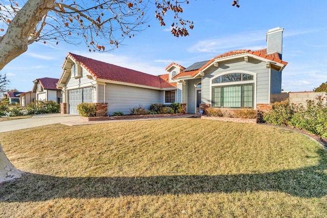 view of front of home with a garage, a front yard, and solar panels