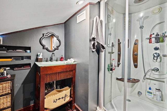 bathroom with crown molding, vanity, and an enclosed shower