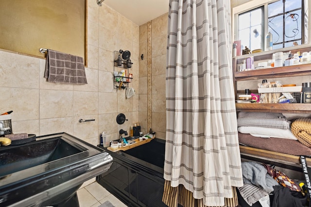 bathroom with tile patterned flooring, tile walls, and sink