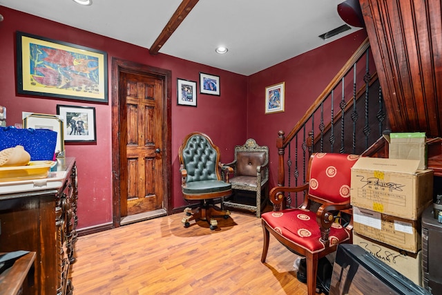 sitting room featuring beamed ceiling and light wood-type flooring