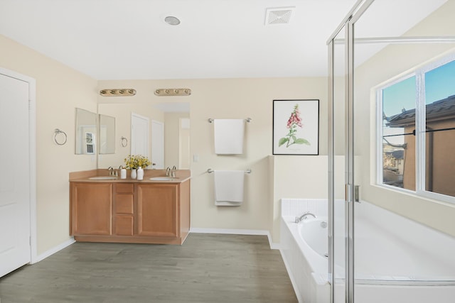 bathroom with vanity, plus walk in shower, and hardwood / wood-style floors