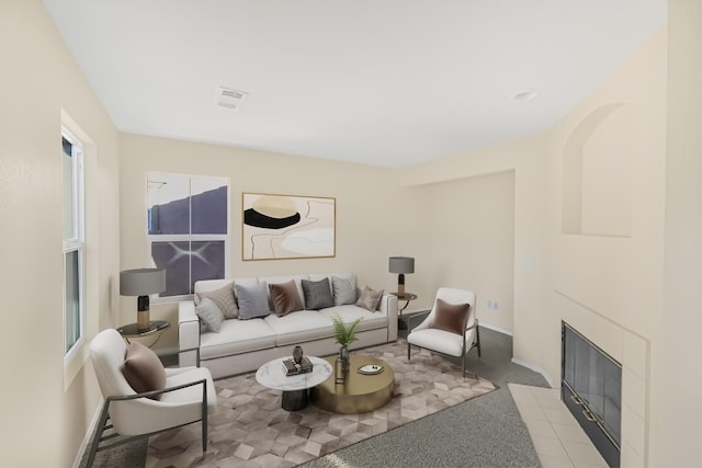 living room featuring a tile fireplace and light carpet