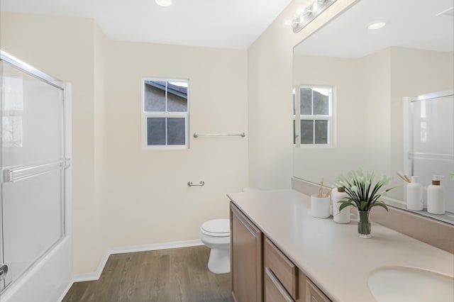 bathroom with wood-type flooring, an enclosed shower, vanity, and toilet