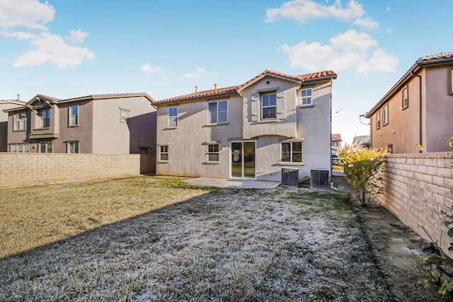 rear view of house featuring a lawn, central AC, and a patio