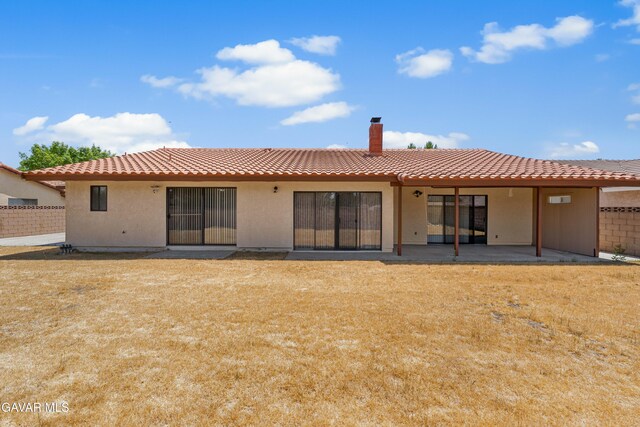 2613 W W Ave K4, Lancaster, CA 93536 - back of property featuring stucco siding, a patio area, a tiled roof, and a chimney