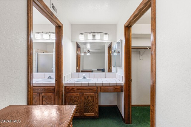 2613 W W Ave K4, Lancaster, CA 93536 - full bath featuring a textured wall, vanity, a ceiling fan, and a shower