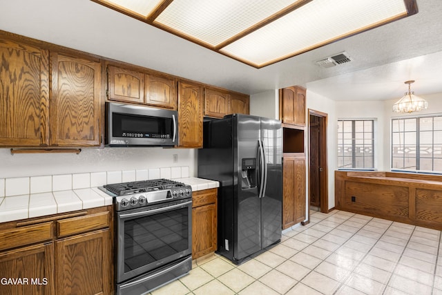 2613 W W Ave K4, Lancaster, CA 93536 - kitchen with appliances with stainless steel finishes, tile countertops, and brown cabinets