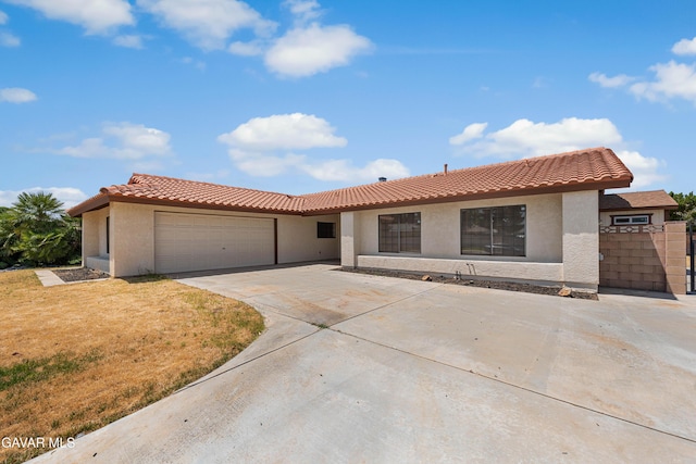 2613 W W Ave K4, Lancaster, CA 93536 - view of front of home featuring stucco siding, an attached garage, driveway, and a tiled roof