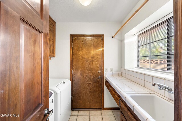 2613 W W Ave K4, Lancaster, CA 93536 - laundry area featuring washer / clothes dryer, cabinet space, and light tile patterned flooring