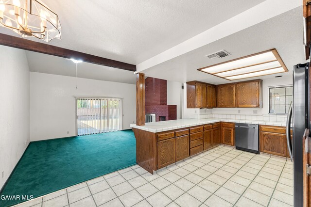 2613 W W Ave K4, Lancaster, CA 93536 - kitchen with stainless steel appliances, brown cabinetry, tile countertops, beamed ceiling, and a textured ceiling