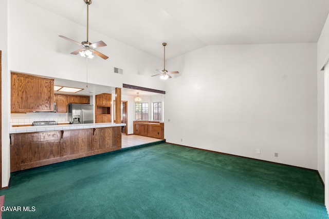 2613 W W Ave K4, Lancaster, CA 93536 - unfurnished living room featuring a ceiling fan, vaulted ceiling, and carpet flooring