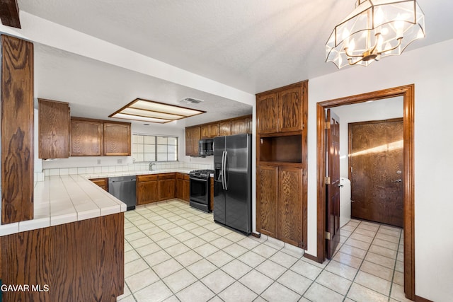 2613 W W Ave K4, Lancaster, CA 93536 - kitchen with stainless steel appliances, tile countertops, a chandelier, and light tile patterned floors