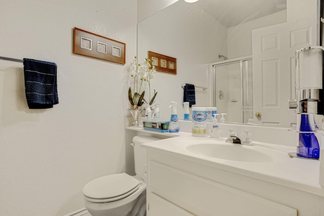 bathroom featuring a stall shower, toilet, and vanity