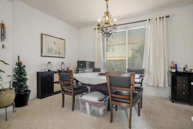 dining room featuring a notable chandelier, baseboards, and light carpet
