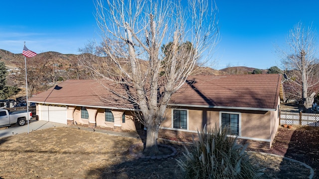 ranch-style home featuring a garage and a mountain view