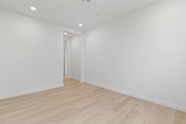 spare room featuring recessed lighting, light wood-style floors, and baseboards