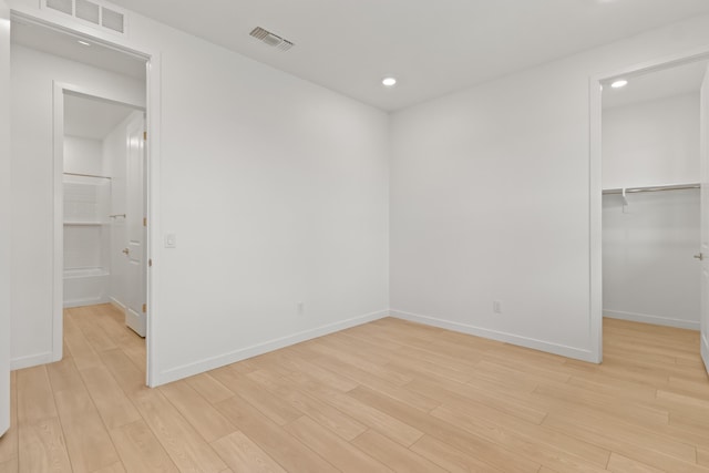 unfurnished room featuring recessed lighting, baseboards, visible vents, and light wood-type flooring