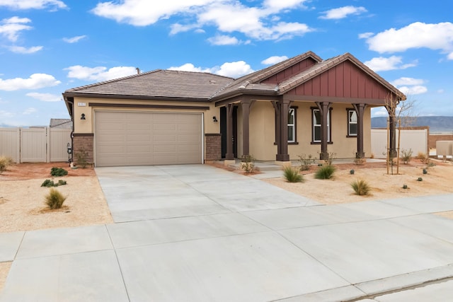 view of front of house with fence, stucco siding, a garage, driveway, and a gate