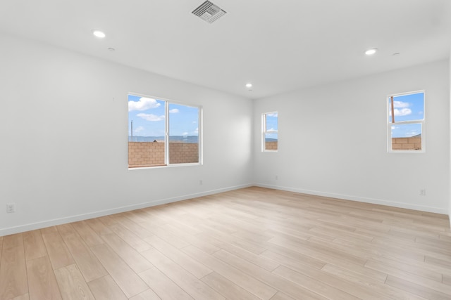 empty room with recessed lighting, visible vents, baseboards, and light wood finished floors