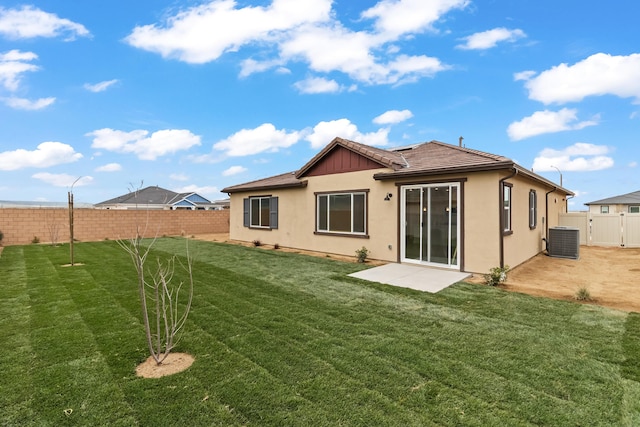 rear view of house featuring central AC, stucco siding, a fenced backyard, a yard, and a patio