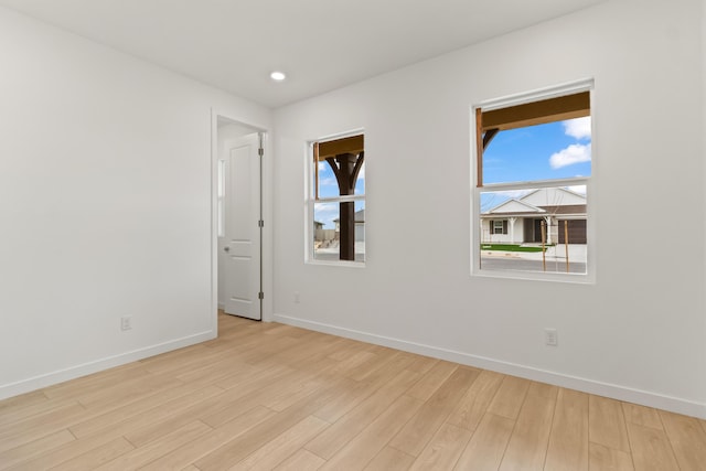 spare room with recessed lighting, baseboards, and light wood finished floors