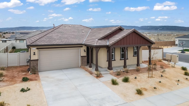 view of front facade with a tiled roof, a mountain view, a garage, and fence