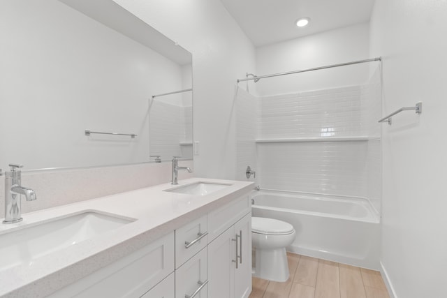 bathroom featuring a sink, shower / bath combination, toilet, and double vanity