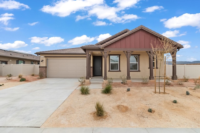 view of front of home with a garage, solar panels, concrete driveway, and fence