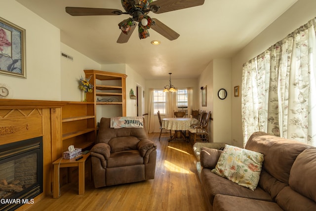 817 W J6, Lancaster, CA 93534 - living area featuring wood finished floors, a ceiling fan, a chandelier, a glass covered fireplace, and recessed lighting