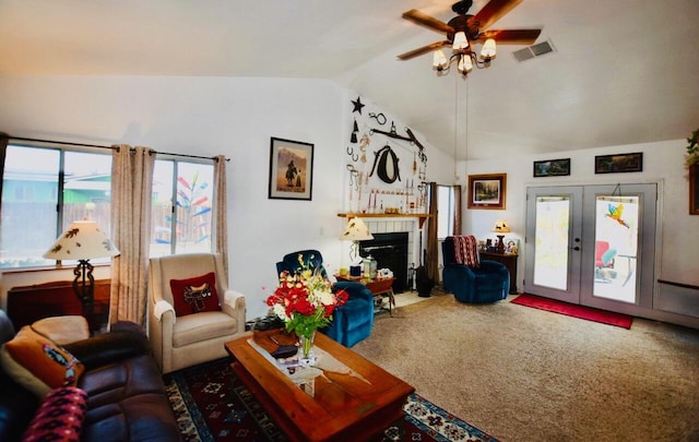 living room with visible vents, a tile fireplace, lofted ceiling, carpet flooring, and french doors