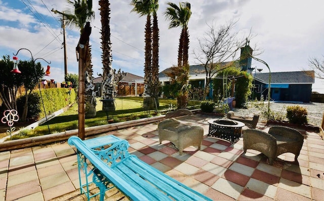 view of patio featuring an outdoor fire pit and fence