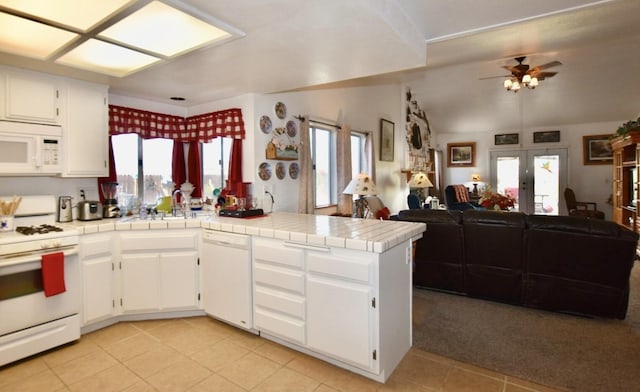 kitchen featuring french doors, a wealth of natural light, open floor plan, white appliances, and a peninsula