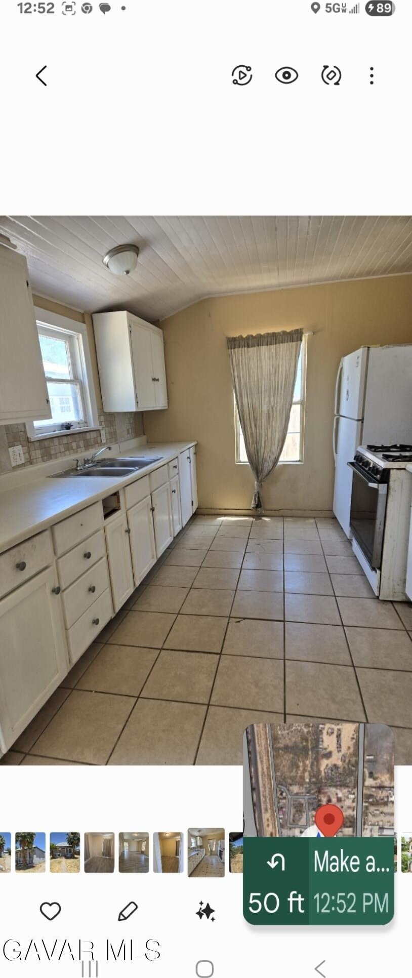 941 W Oldfield St, Lancaster, CA 93534 - kitchen featuring white gas range, light tile patterned floors, white cabinets, light countertops, and vaulted ceiling