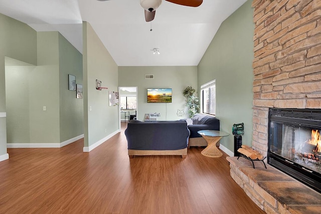 living room featuring hardwood / wood-style flooring, ceiling fan, a fireplace, and a wealth of natural light