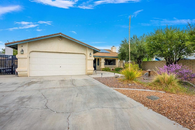 ranch-style house featuring solar panels and a garage