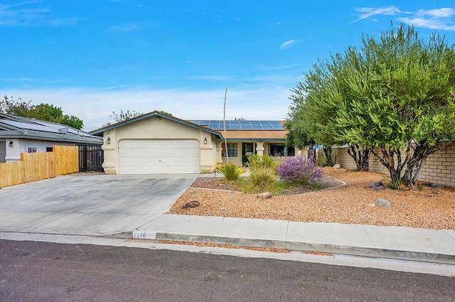 ranch-style house with a garage and solar panels