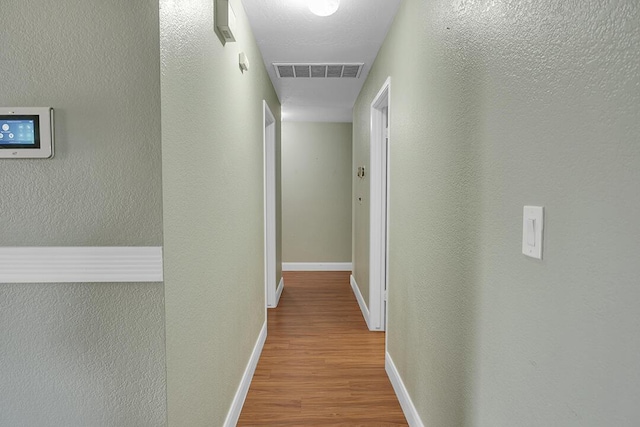 corridor with light hardwood / wood-style floors