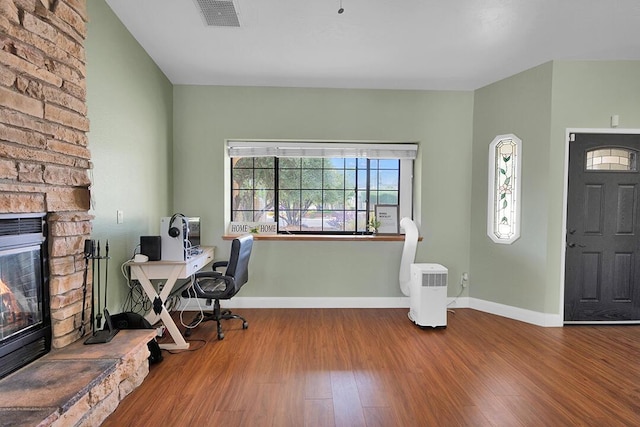 office space featuring hardwood / wood-style floors and a fireplace