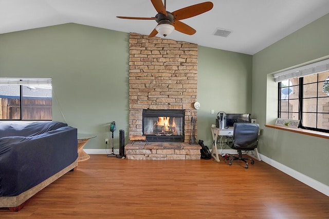 living room featuring a fireplace, hardwood / wood-style flooring, vaulted ceiling, and ceiling fan