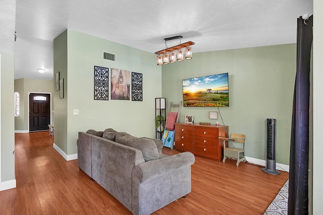 living room with hardwood / wood-style flooring and a chandelier