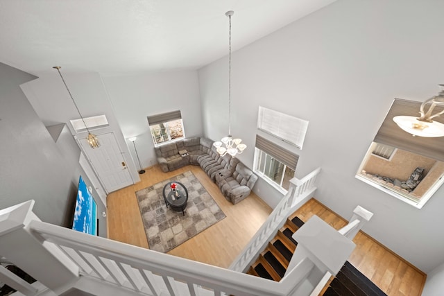 36933 Cadmia Ct, Palmdale, CA 93552 - living room featuring wood finished floors, a chandelier, high vaulted ceiling, and stairs