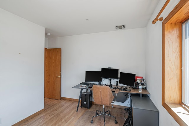 office featuring baseboards, visible vents, and wood finished floors