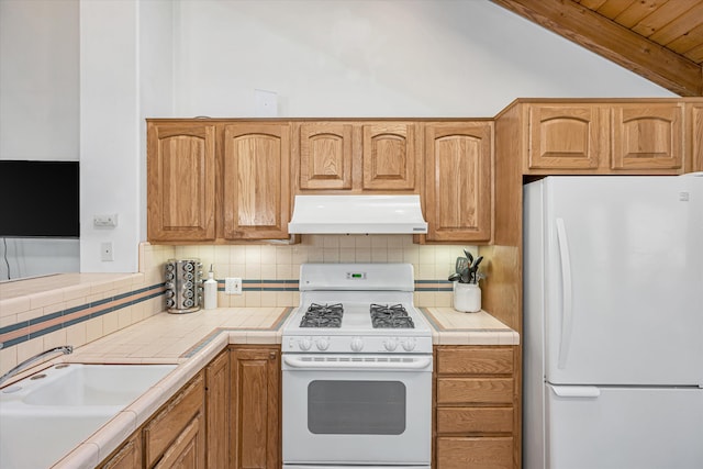 kitchen with extractor fan, white appliances, a sink, tile counters, and decorative backsplash