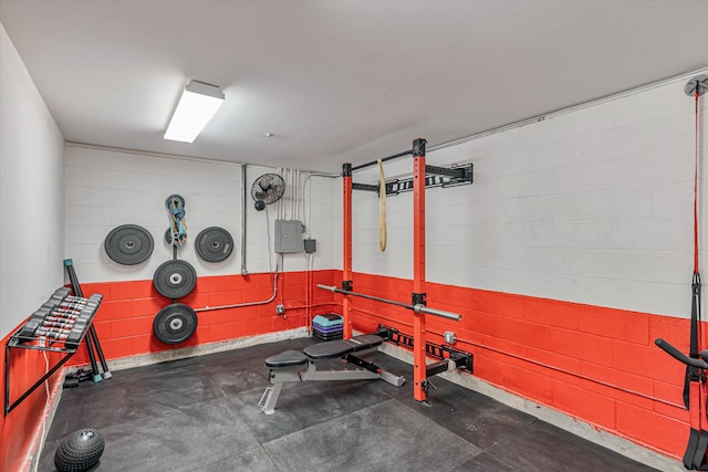 exercise room featuring concrete block wall