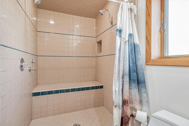 full bath featuring a tile shower and toilet