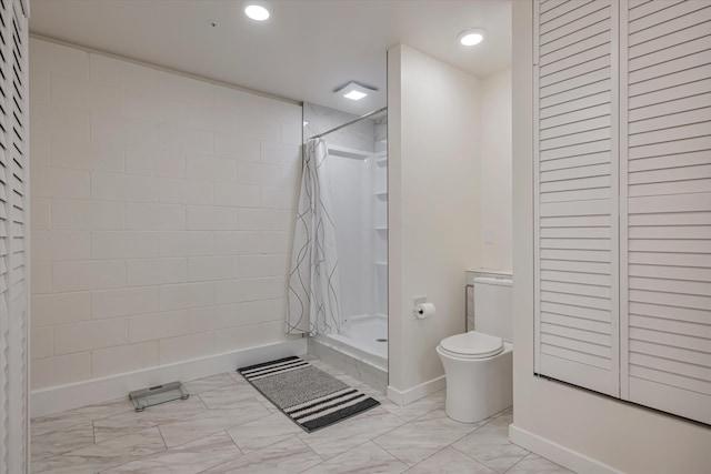 bathroom with a stall shower, marble finish floor, baseboards, and toilet