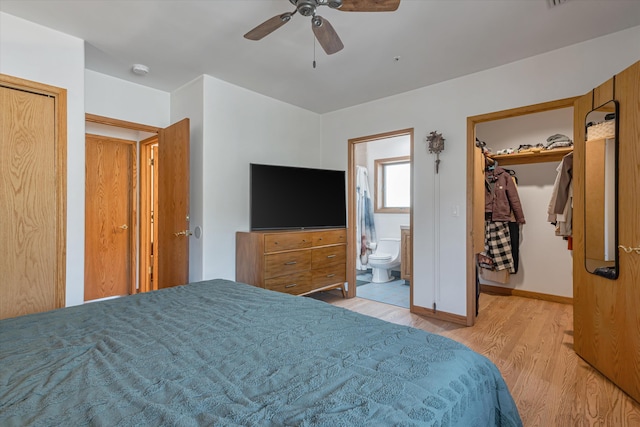 bedroom featuring ensuite bathroom, wood finished floors, baseboards, a spacious closet, and a closet