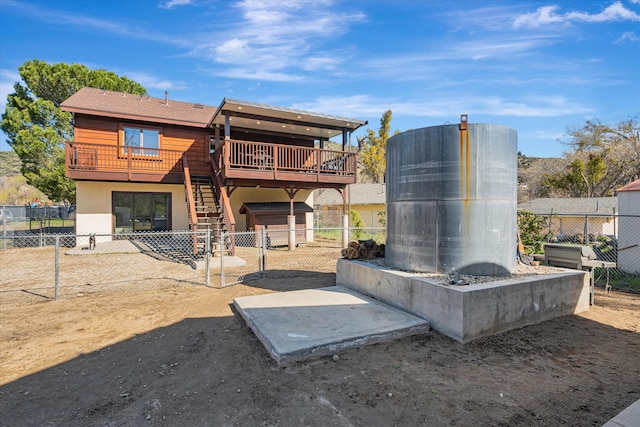 exterior space featuring stucco siding, stairway, a fenced backyard, an outdoor structure, and a wooden deck